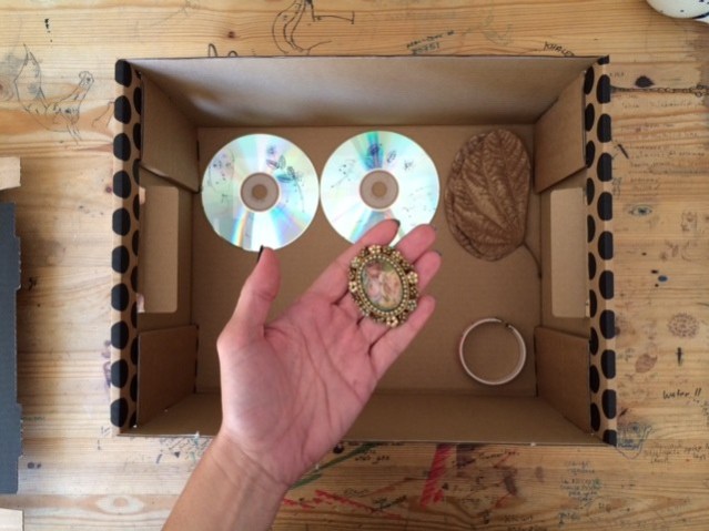 circular objects: a brooch i bought from paris eons ago, two blank cds a leaf i picked up outside the palms hotel and a lebanon bracelet from international day at a.s.k.