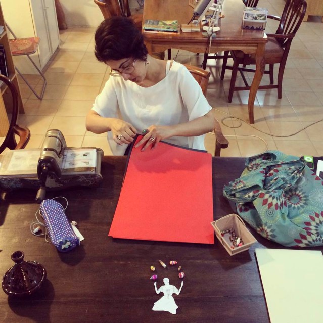 lubna sorts through multi-colored clairefontaine paper while eve plays