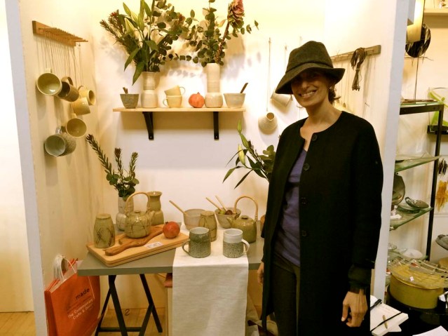 sarah in her new hat by elizabeth renton's ceramic display. it was the pomegranates that attracted our attention to this thoughtfully put-together booth