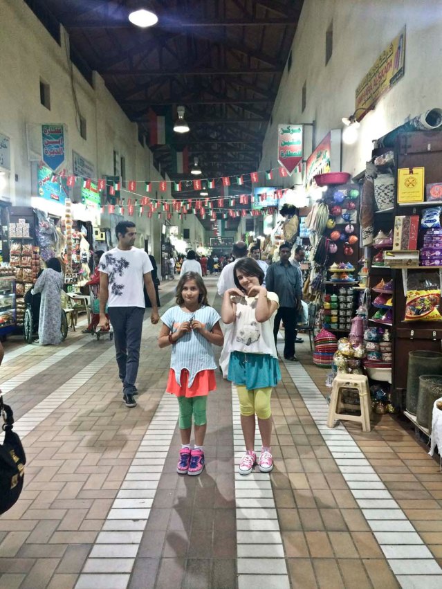 colorful girls, teapots and bunting in one of mubarakiya's many corridors